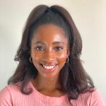 Close shot of Diane smiling, wearing a pink sweater